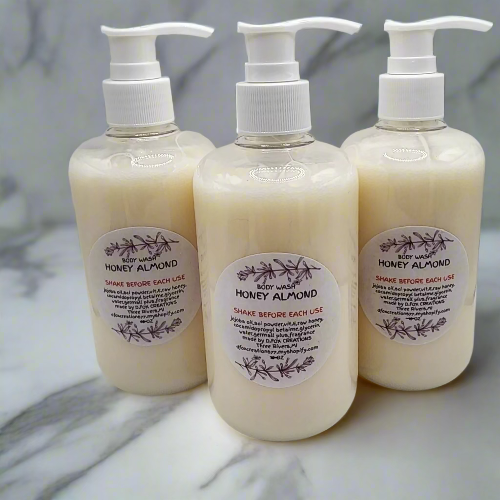 Three bottles of Honey Almond lotion on a white surface with a gray chair in the background.